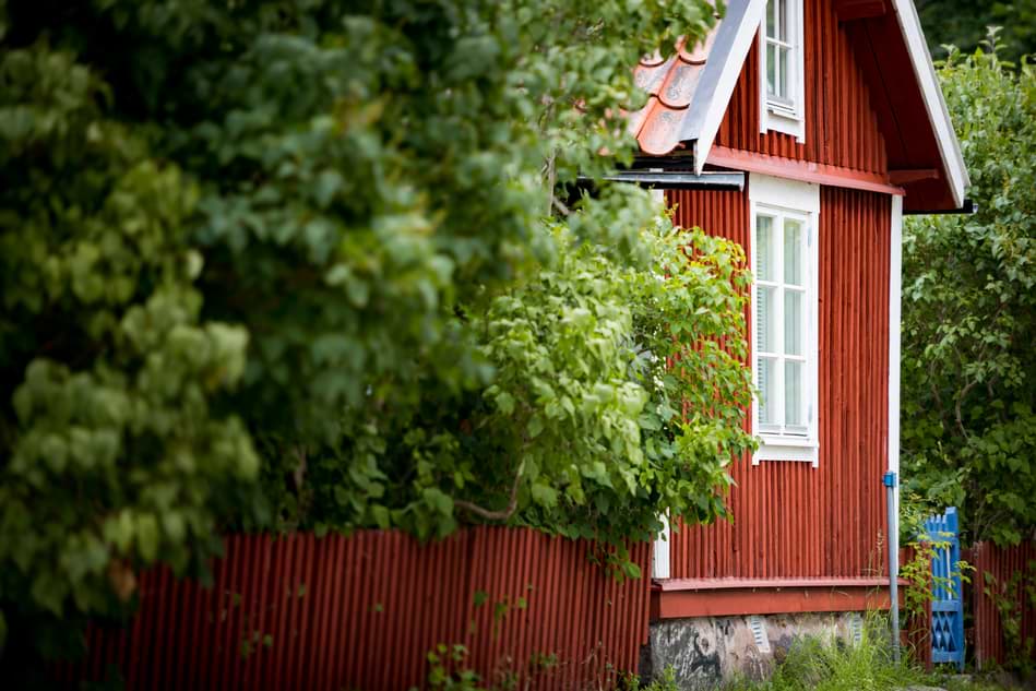 Röd sommarstuga bland grönska
