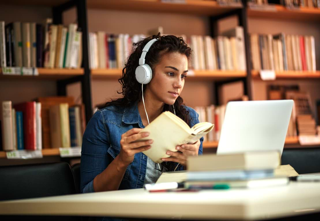 Studerande kvinna i bibliotek