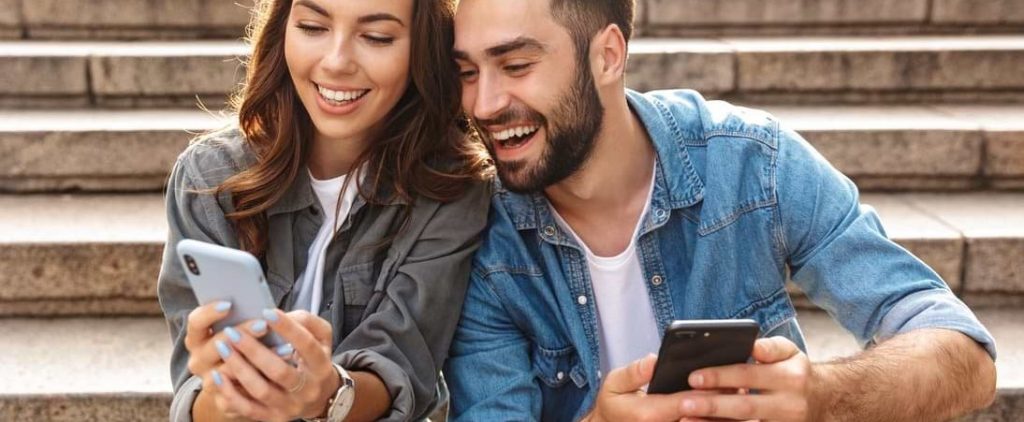 Kvinna och man jämför möjligheten att låna pengar utan säkerhet på mobilen.