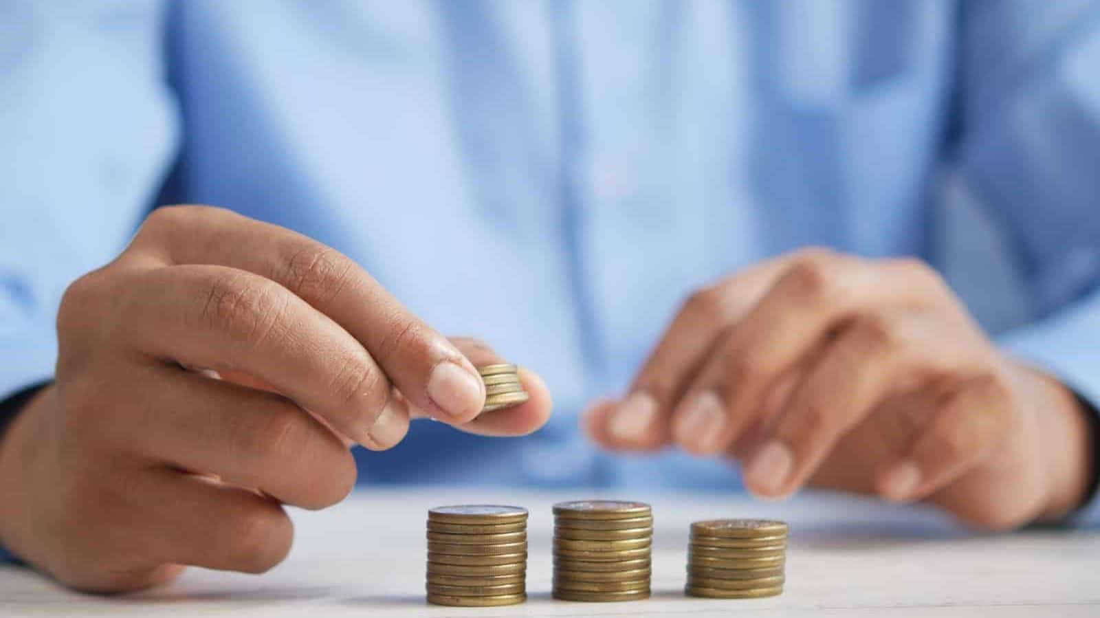 en person staplar mynt på ett bord som symbol för att bygga bättre lånevillkor